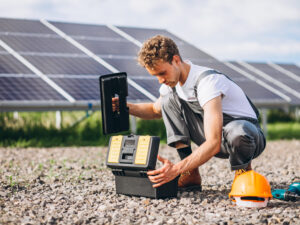 Man worker in the firld by the solar panels